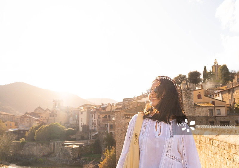 阳光明媚的加泰罗尼亚，冬季假期中的光彩照人的女性与中世纪小镇图片素材
