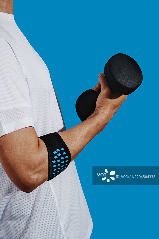 男子佩戴肱骨外上髁炎手环举重图片素材