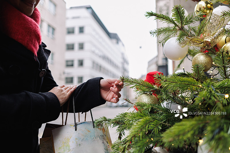 年轻的亚洲女性在购物时挑选圣诞树图片素材