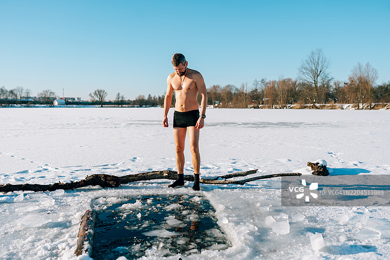 勇敢的男人准备在冰冻湖中跳入冰水图片素材