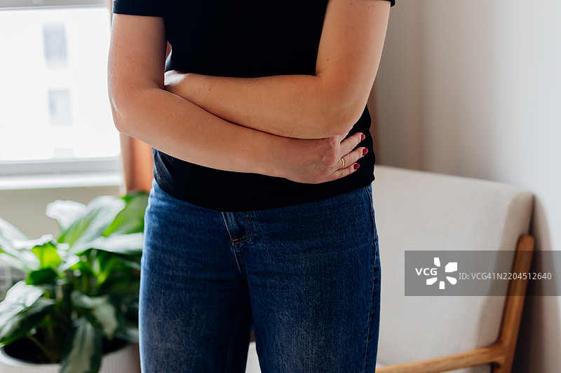 腹痛的女性捂着肚子，面露痛苦。医疗和健康概念。图片素材