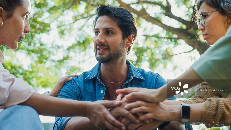 特写镜头下的多元化人群参与支持性团体治疗会议，分享个人故事和建议，以促进心理健康和康复，地点在公园。心理健康社区概念。图片素材