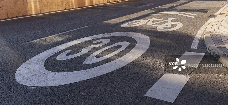 在沥青路面上绘制的限速和自行车道标志图片素材