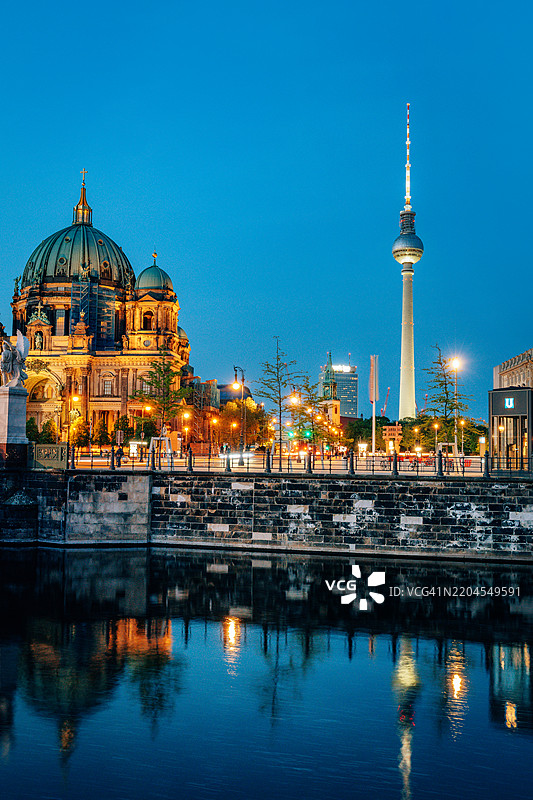 柏林大教堂和电视塔在黄昏时分灯光璀璨，倒映在河面上图片素材