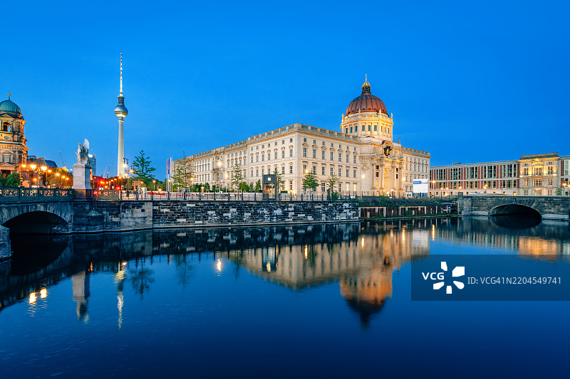照亮的柏林城市夜景与河流倒影图片素材