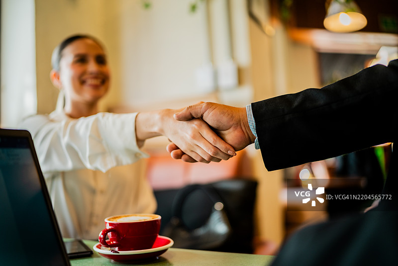同事在咖啡店握手的特写镜头图片素材