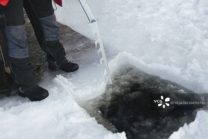 老年女性在冰冻土地上挖洞的下半身图片素材