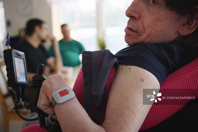 一位成熟的脑瘫男性佩戴着紧急呼叫按钮手环图片素材