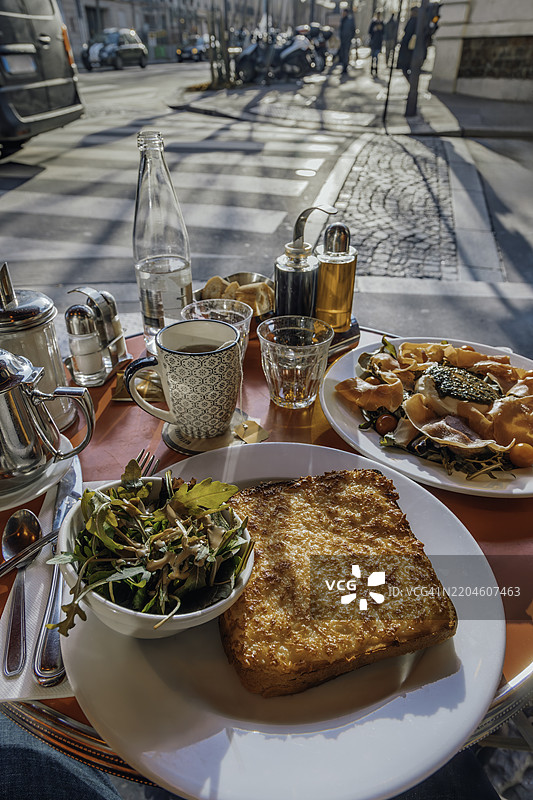 在法国巴黎的街边咖啡馆享用美味的法式早餐图片素材