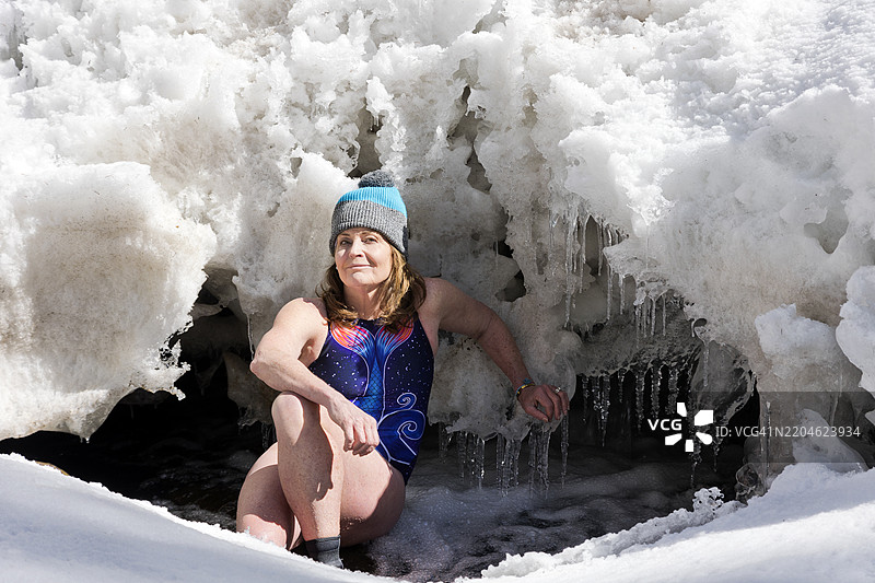 在自然雪溪中进行冷水浴的老年女性图片素材