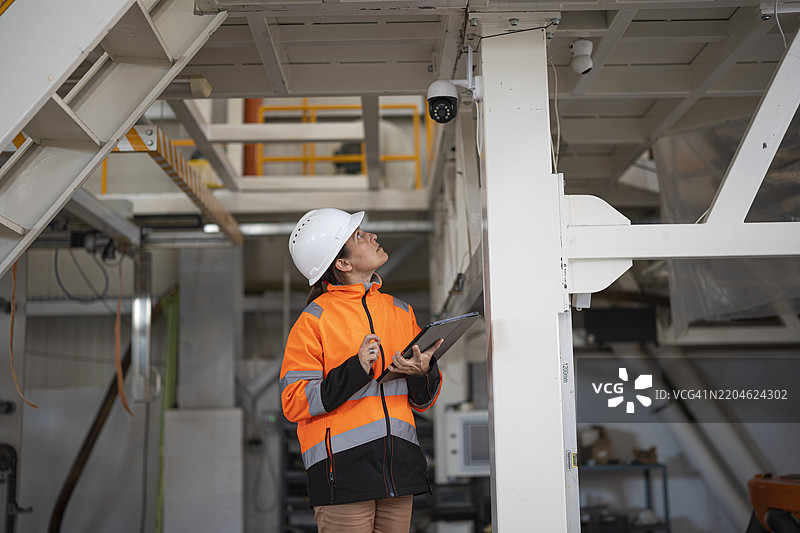 网络工程师在工厂检查工业IP安全摄像头图片素材