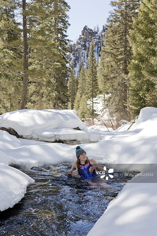 在自然雪溪中进行冷水浸泡的老年女性图片素材