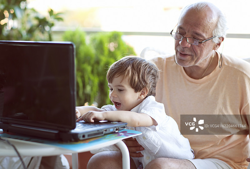 祖父和孙子一起享受高质量的科技时光图片素材