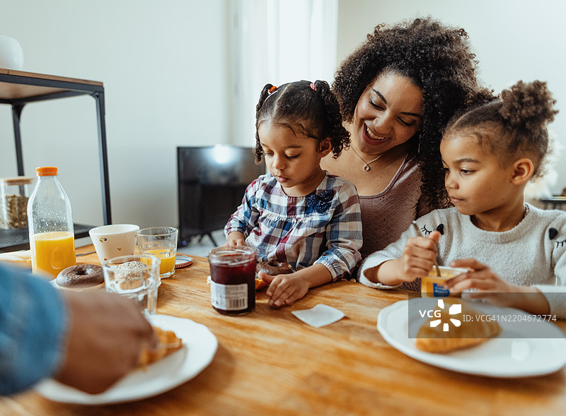 一家四口与两个小女儿一起享用早餐图片素材