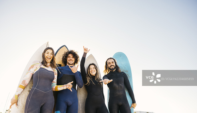 冲浪者在海滩上做出“沙卡”手势图片素材