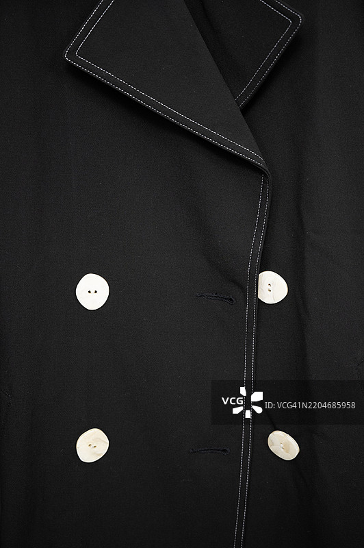 一件黑色外套，配有白色纽扣和白色边饰图片素材