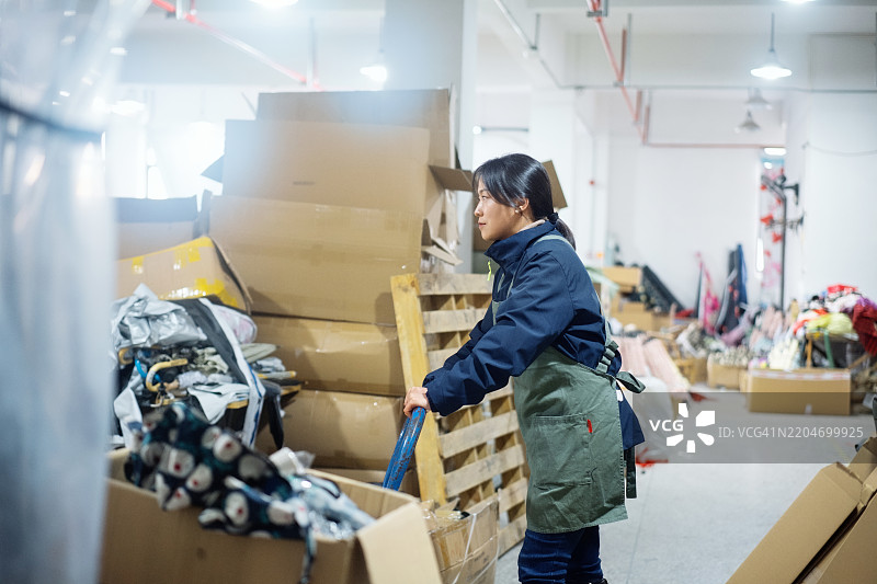 亚洲女性蓝领工人在仓库中派送货物图片素材