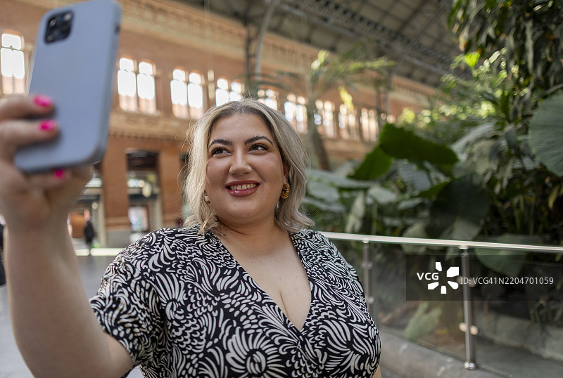 年轻女性在马德里阿托查车站自拍图片素材