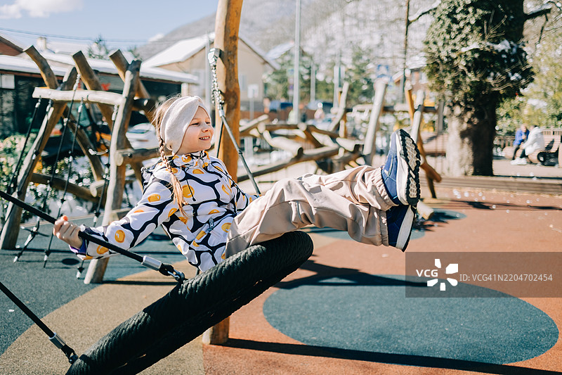 冬天快乐的孩子在秋千上荡秋千图片素材
