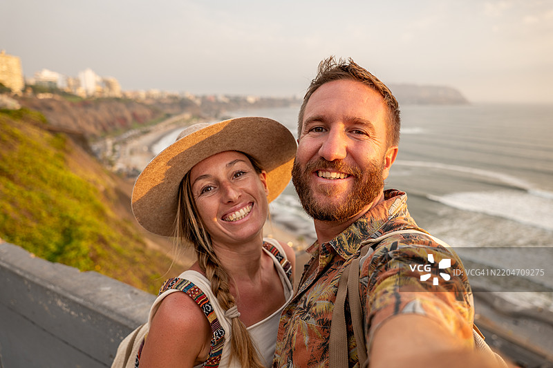 情侣在利马日落时拍自拍照图片素材