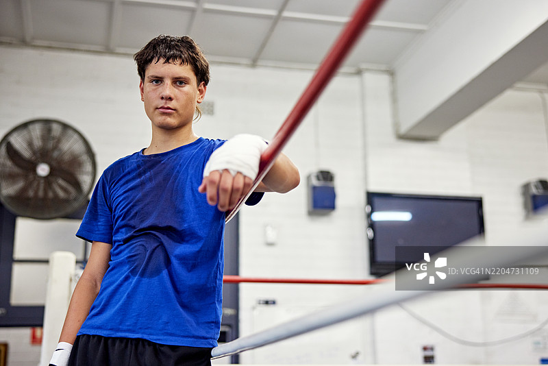 训练后满身汗水的年轻拳击手的场边肖像图片素材