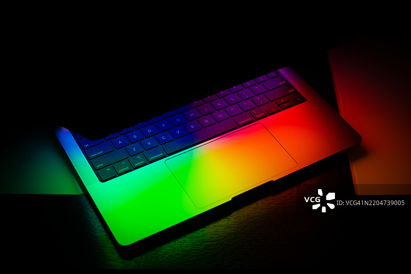 黑色背景下发光的笔记本电脑图片素材