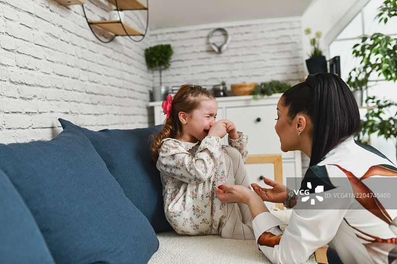 关心的母亲安慰因失去心爱玩具而伤心的女儿图片素材