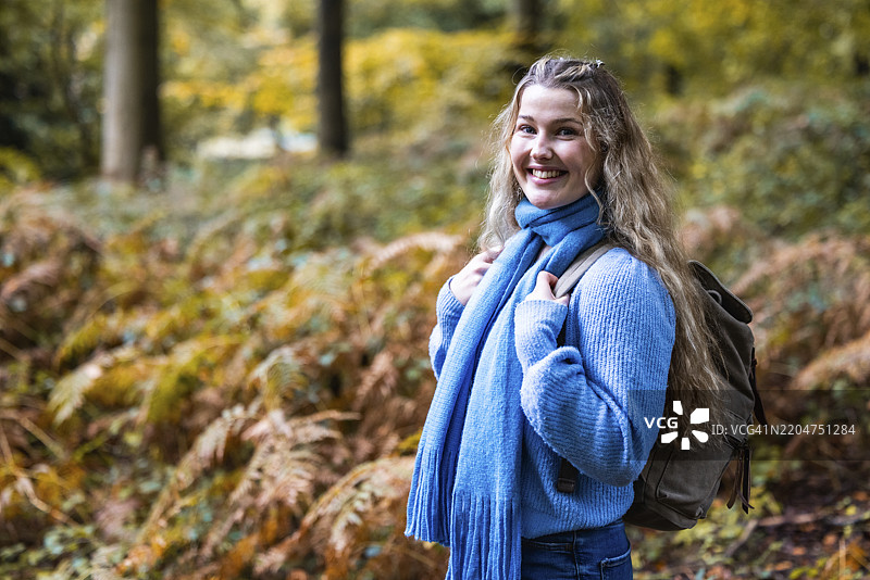 微笑的美丽女性背着背包站在坎诺克追逐森林中图片素材
