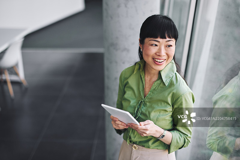 微笑的日本女商人在办公室使用平板电脑图片素材