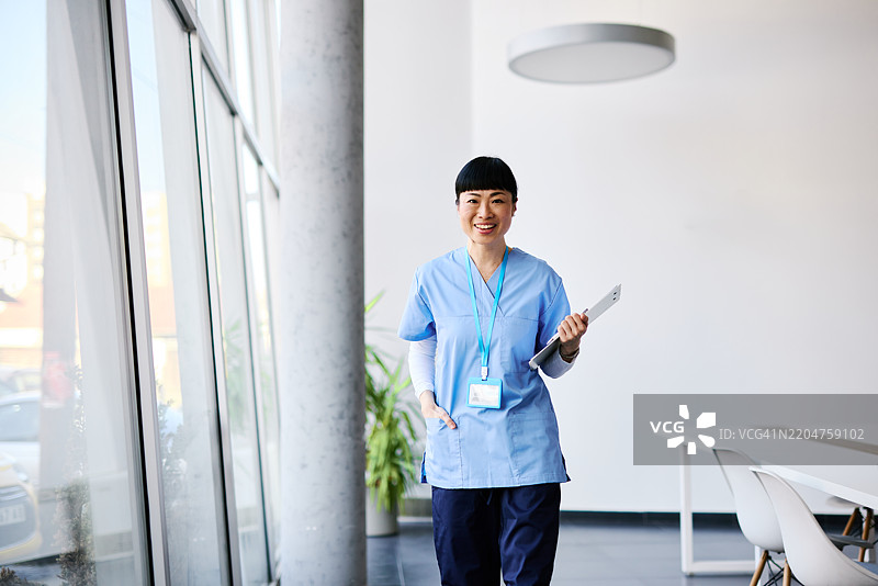 微笑着走在医院走廊里的日本护士图片素材