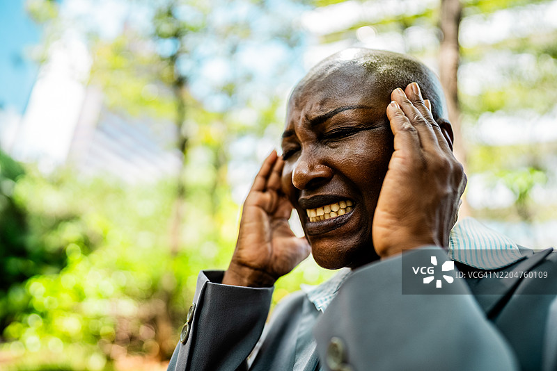成熟的女商人在户外感到头痛图片素材