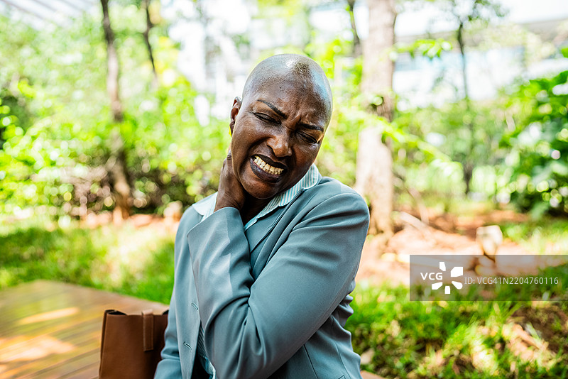 公园里颈部疼痛的成熟的女商人图片素材