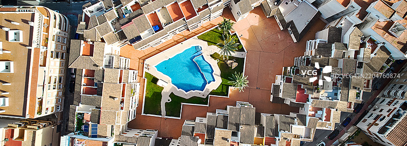 现代住宅综合体的鸟瞰图，围绕中央蓝色游泳池排列，横向照片图片素材