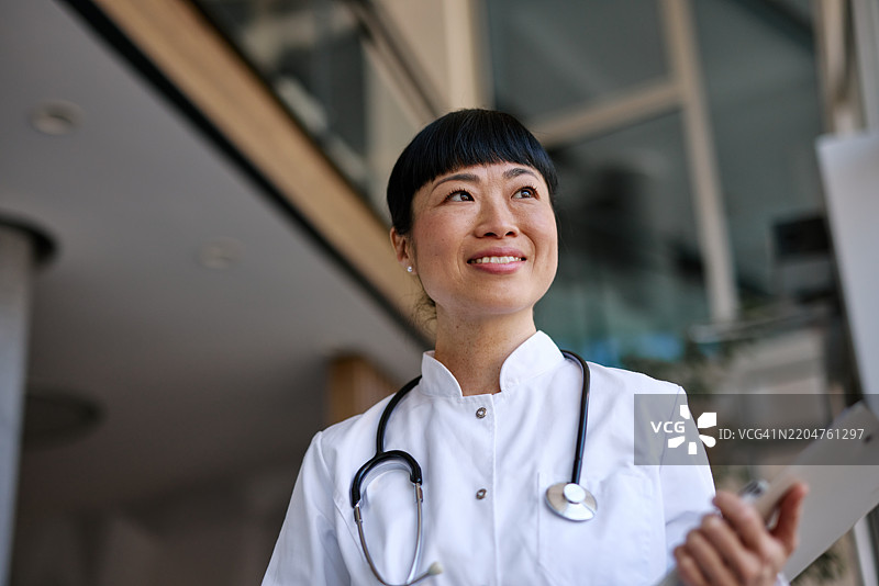 微笑着仰望的日本女性医生在现代医院中图片素材