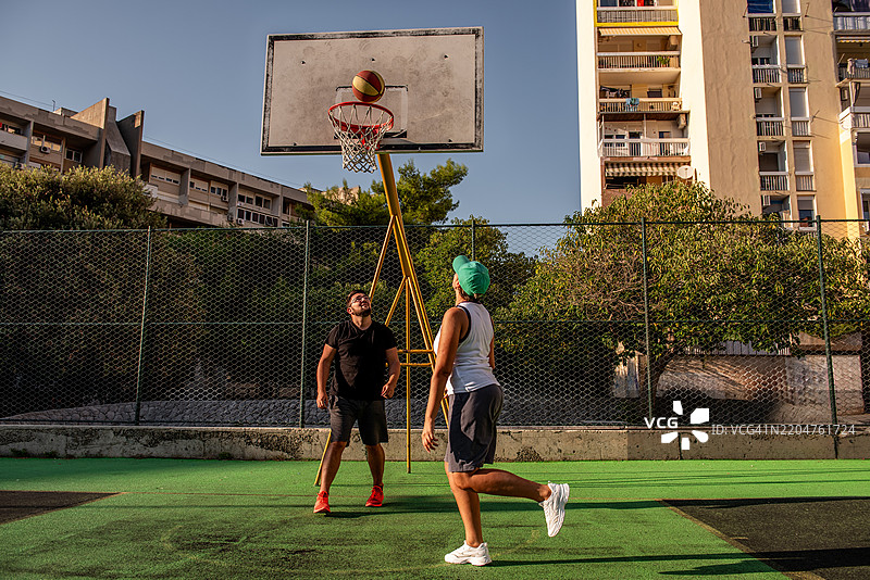 年轻情侣在城市户外打篮球图片素材