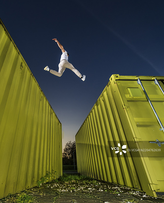 年轻男子在集装箱上练习自由奔跑图片素材