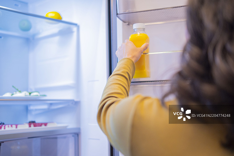 孕妇从冰箱里拿果汁瓶图片素材