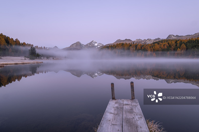 秋季瑞士恩加丁的斯塔兹湖，木栈道和晨雾中的日出图片素材