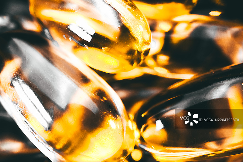 金色胶囊特写，用于延年益寿和健康提升图片素材