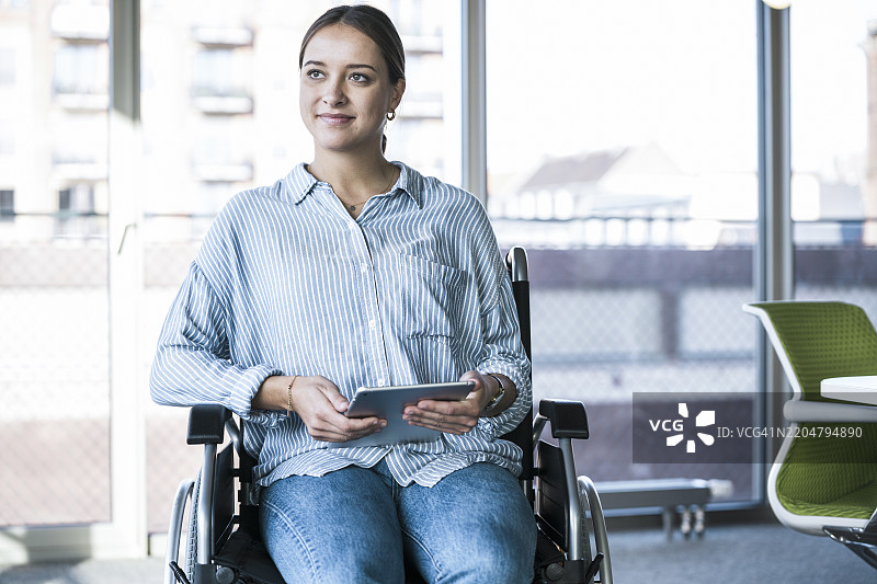 坐在办公室轮椅上的残疾女商人图片素材