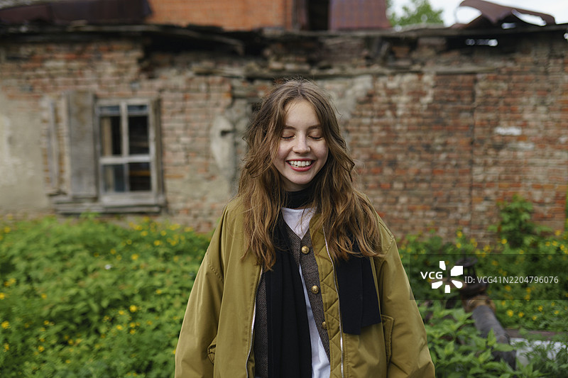 微笑的女性穿着夹克在后院里图片素材