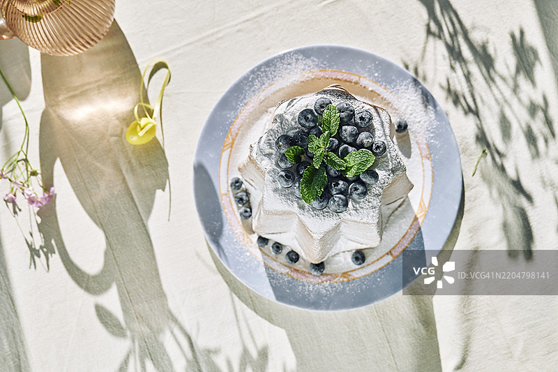 装饰有糖霜和蓝莓的潘多罗面包放在盘子上图片素材