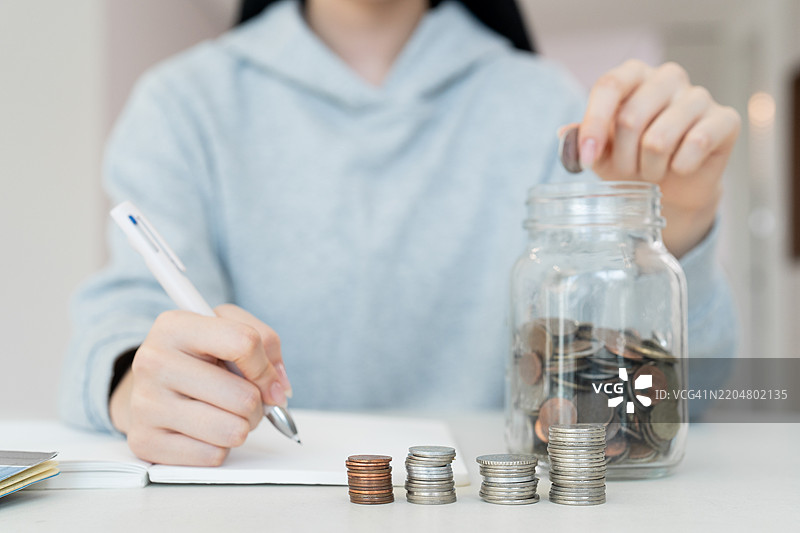独自生活的成年女性，单身，储蓄，银行，存折，储蓄罐，硬币，硬币捆图片素材