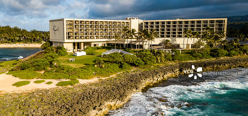 夏威夷海龟湾美丽的海岸景观，度假村与壮观的海浪在戏剧性的云层映衬下。图片素材