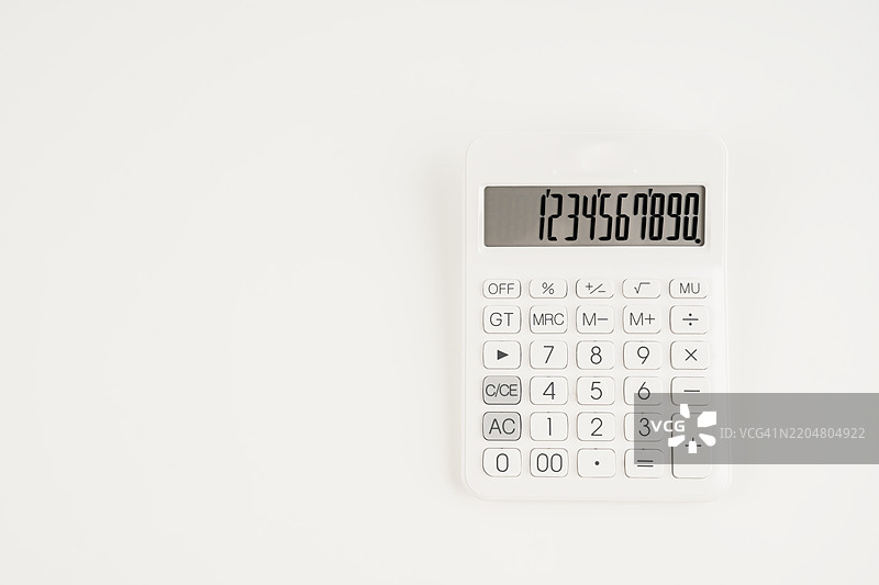白色计算器在白色背景上的位置，留有空白空间。图片素材