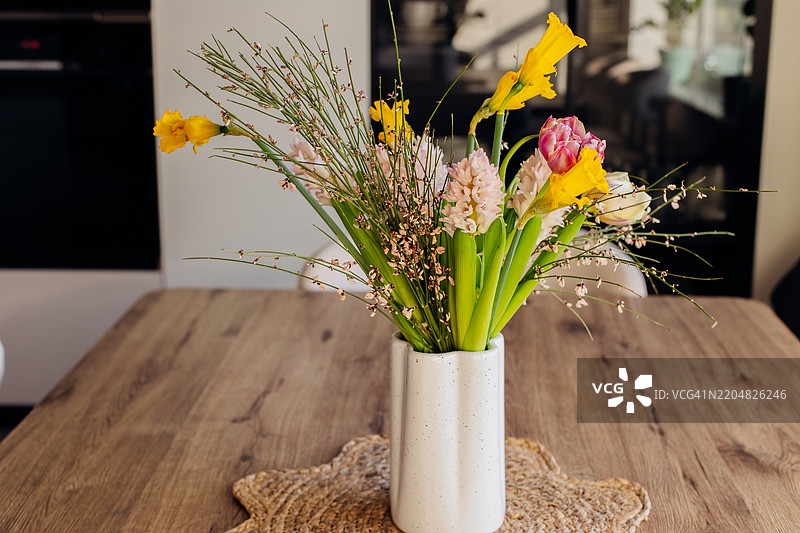 白色陶瓷花瓶中的春季花束。风信子、郁金香和水仙。春天、复活节和母亲节的节日概念。图片素材