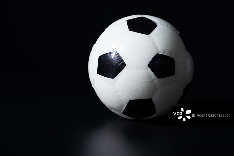 黑色背景上的足球。图片素材
