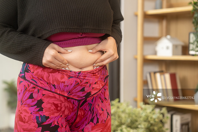 在舒适的房间环境中，穿着彩色裤子的人正在检查身体图片素材