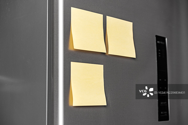 在冰箱上使用便利贴作为备忘录。图片素材