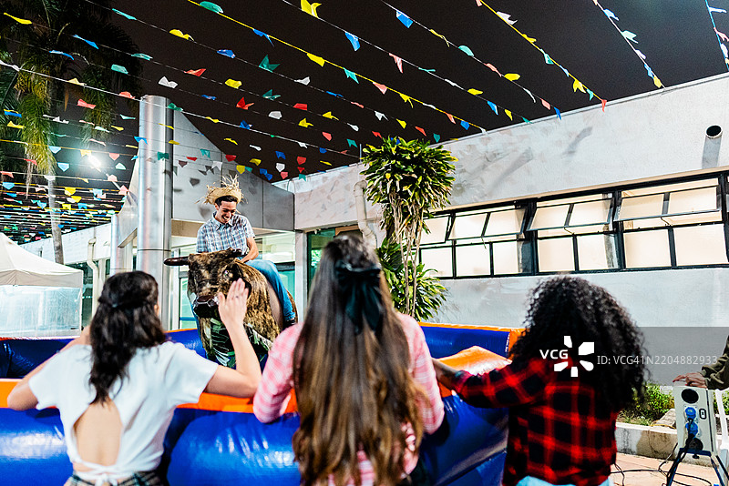 年轻男子在巴西传统节日“六月节”上骑机械公牛图片素材